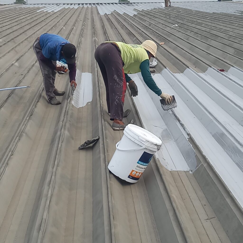 Proses aplikasi Durapruf Silicone Waterproofing pada atap bangunan komersial
